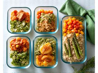 Neatly organized meal prep containers filled with healthy, colorful meals, demonstrating efficient cooking strategies for busy adults.